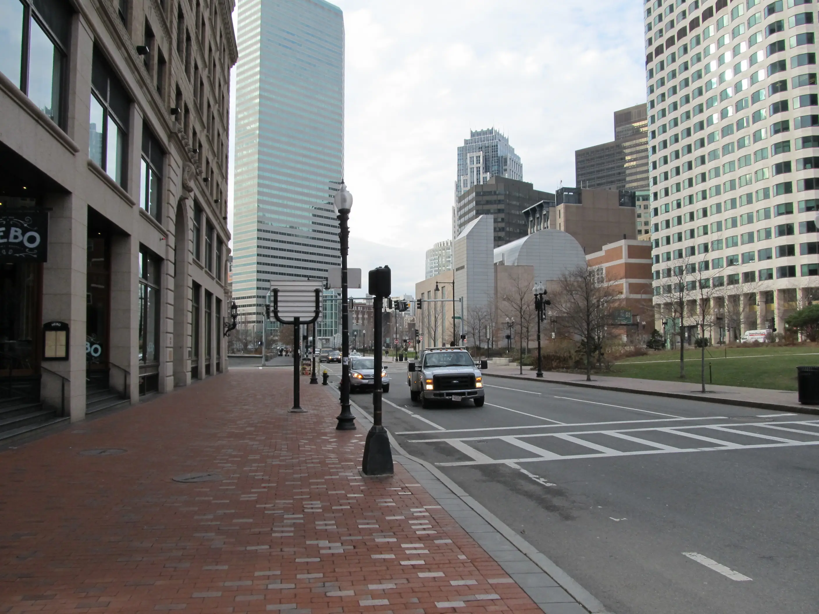 Calle del centro de la ciudad con edificios de oficinas altos y árboles