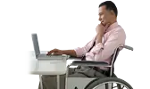 Hombre en silla de ruedas trabajando en una computadora portátil en un escritorio
